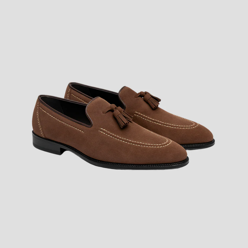 "Mocassins en daim pour homme, vue latérale, couleur marron avec pampilles élégantes, semelle caoutchouc, style raffiné."