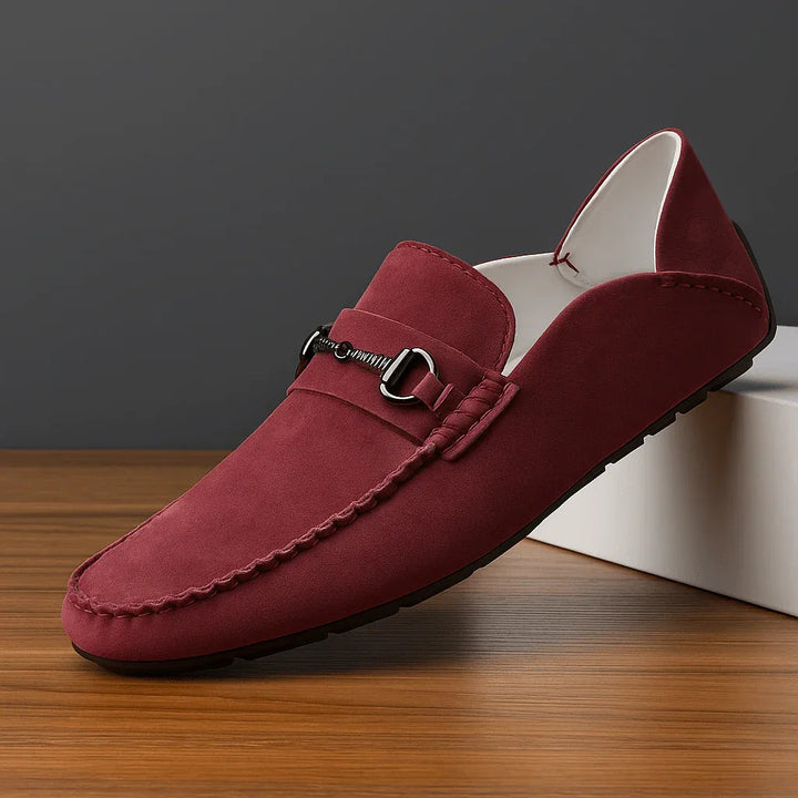 Vue rapprochée de mocassins hommes à enfiler, avec ornements métalliques brillants. Design moderne et élégant.