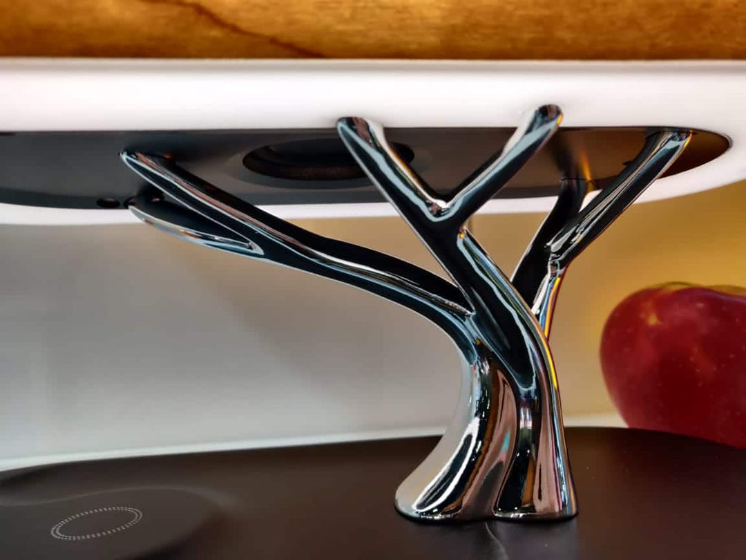 Modern tree-shaped desk lamp with wireless charging & Bluetooth speaker. Adjustable light, elegant design.