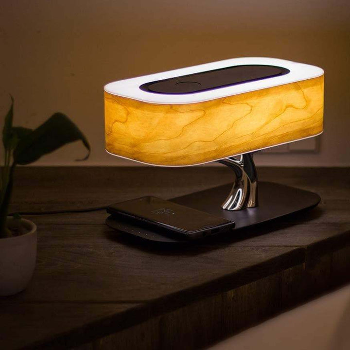 Modern tree-shaped desk lamp with wireless charging & Bluetooth speaker. Adjustable light, elegant design.