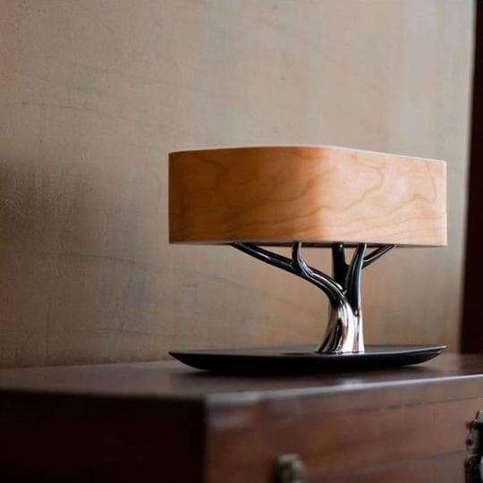 Modern tree-shaped desk lamp with wireless charging & Bluetooth speaker. Adjustable light, elegant design.