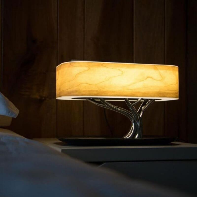 Modern tree-shaped desk lamp with wireless charging & Bluetooth speaker. Adjustable light, elegant design.