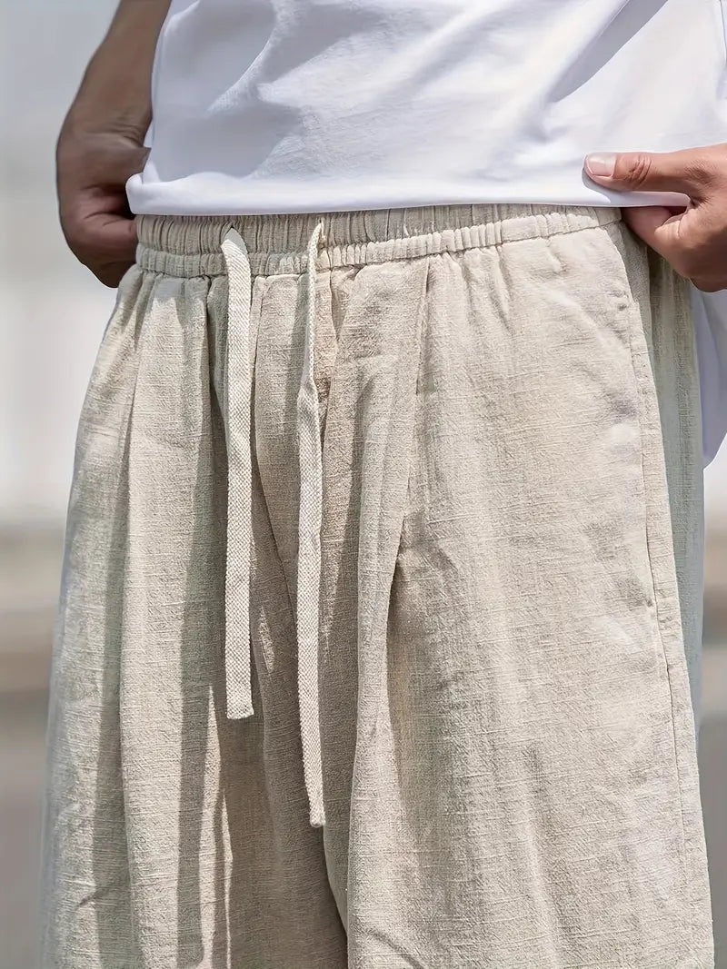 Mode homme: pantalon décontracté ample en lin kaki, essentiel pour les loisirs estivaux et le bien-être.