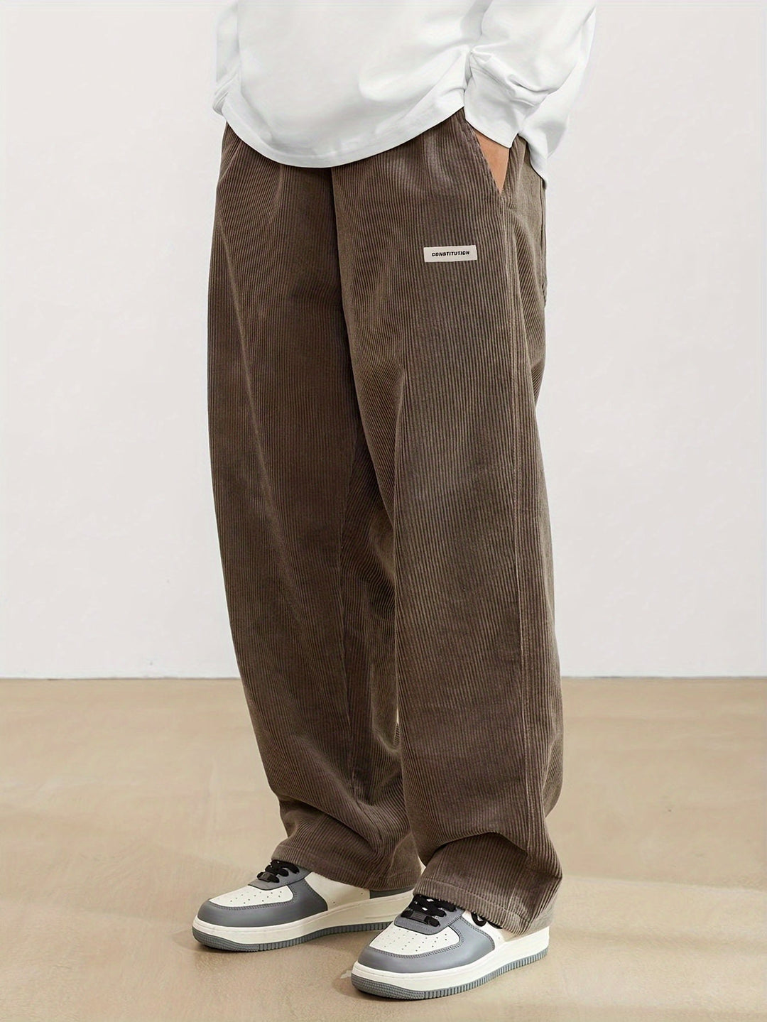 Pantalon ample en velours côtelé noir pour hommes, offrant confort et style moderne, parfait pour un look décontracté.