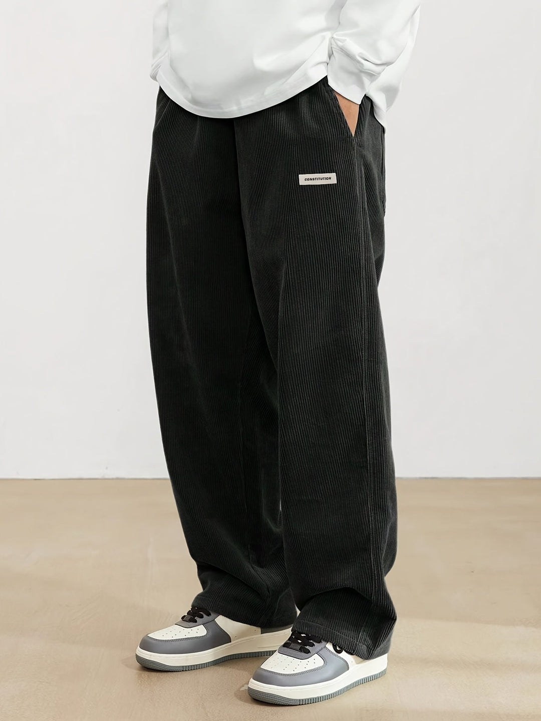 Pantalon ample en velours côtelé noir pour hommes, offrant confort et style moderne, parfait pour un look décontracté.