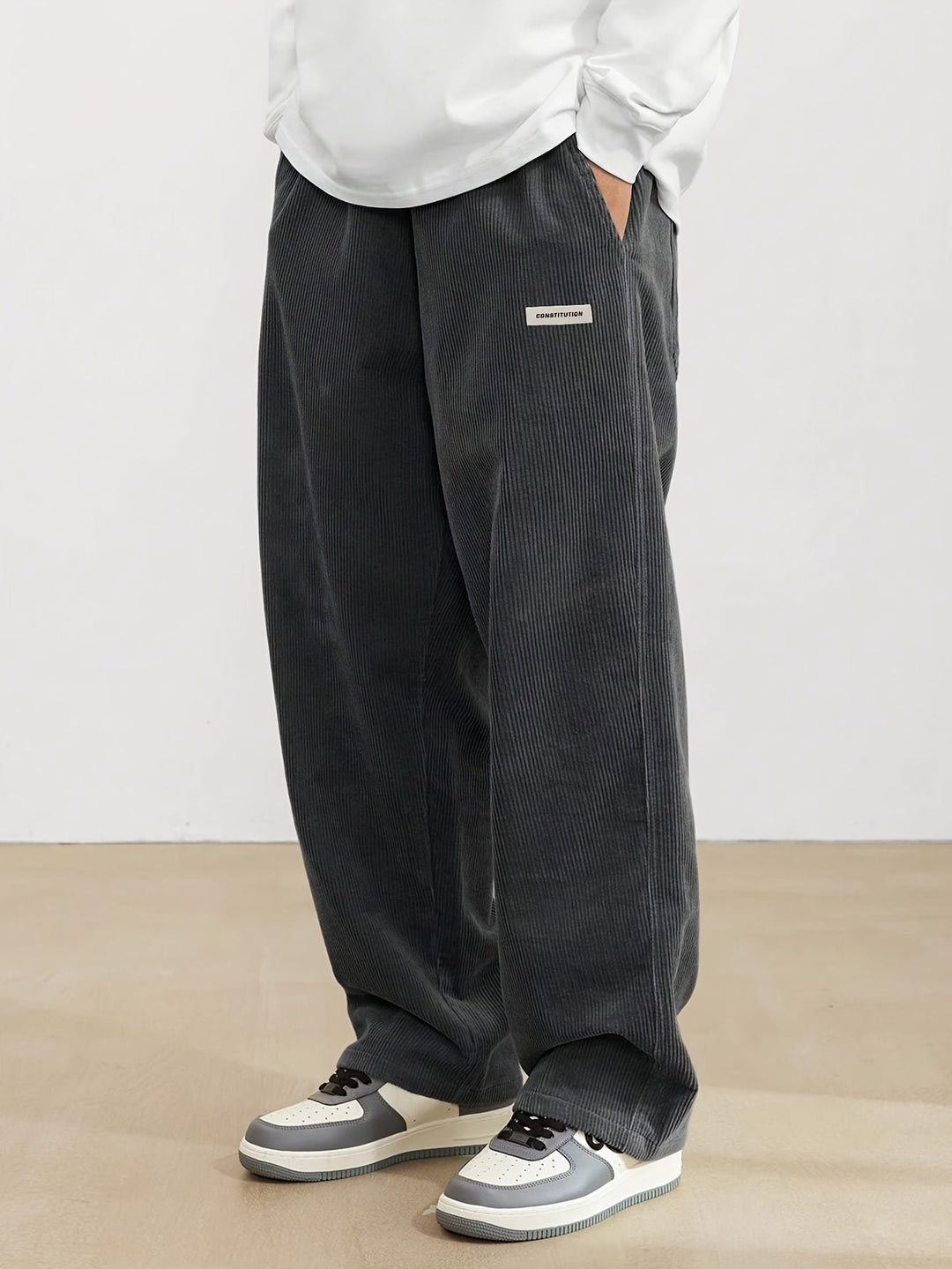 Pantalon ample en velours côtelé noir pour hommes, offrant confort et style moderne, parfait pour un look décontracté.