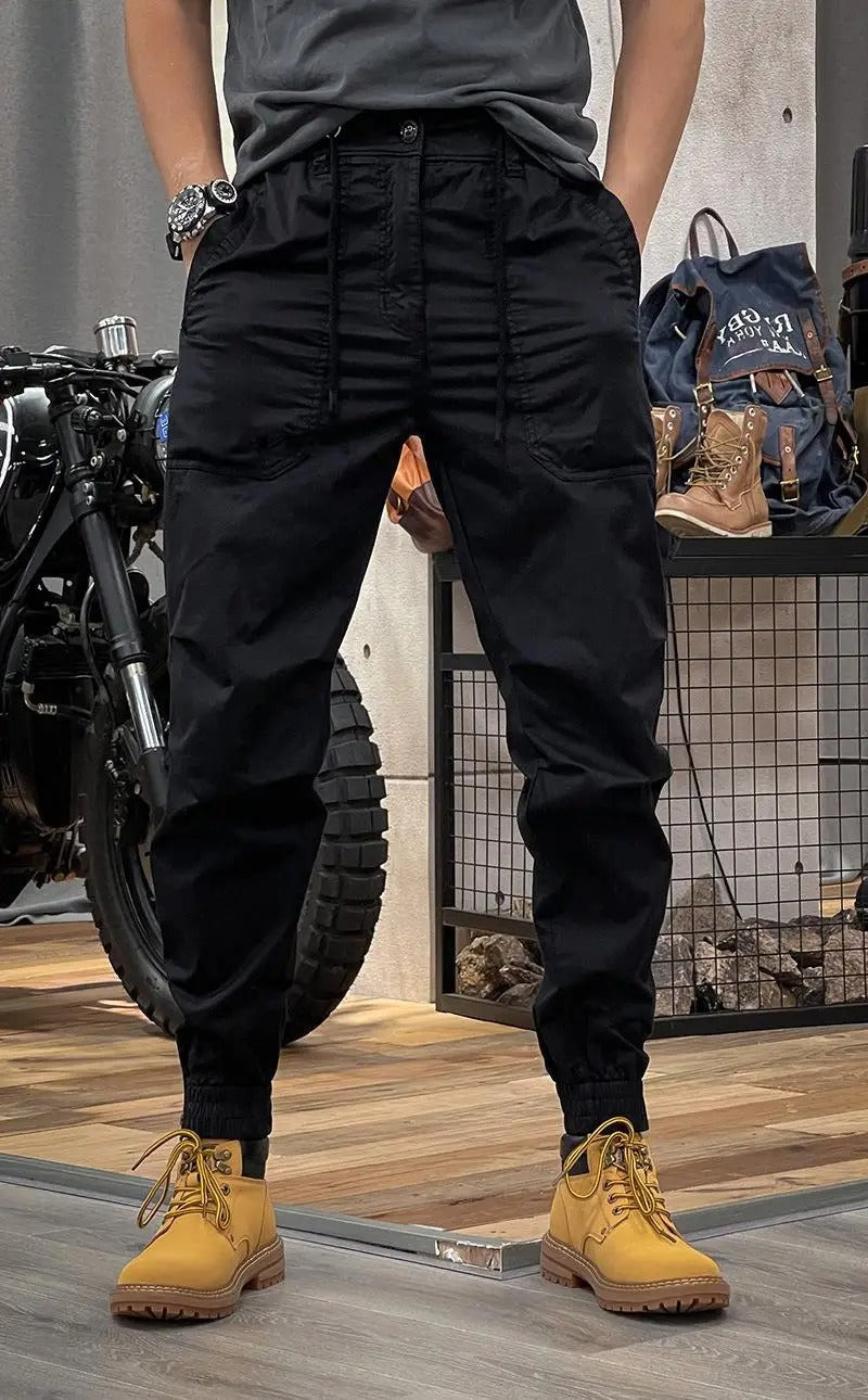 Cargo noir homme avec poches utilitaires, tissu stretch, allie fonctionnalité et mode masculine urbaine.