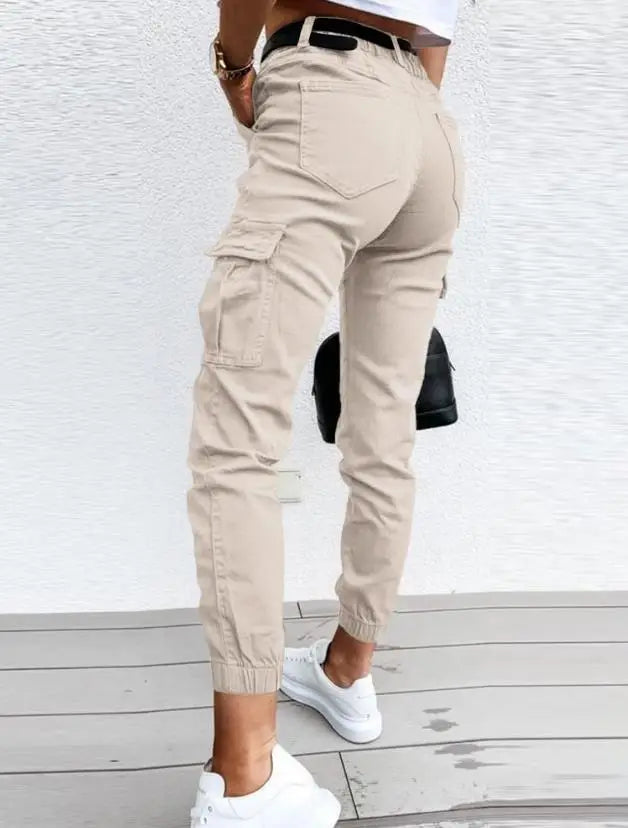 Pantalon cargo femme noir, coupe ample, porté dans un cadre urbain, alliant mode décontractée et style.
