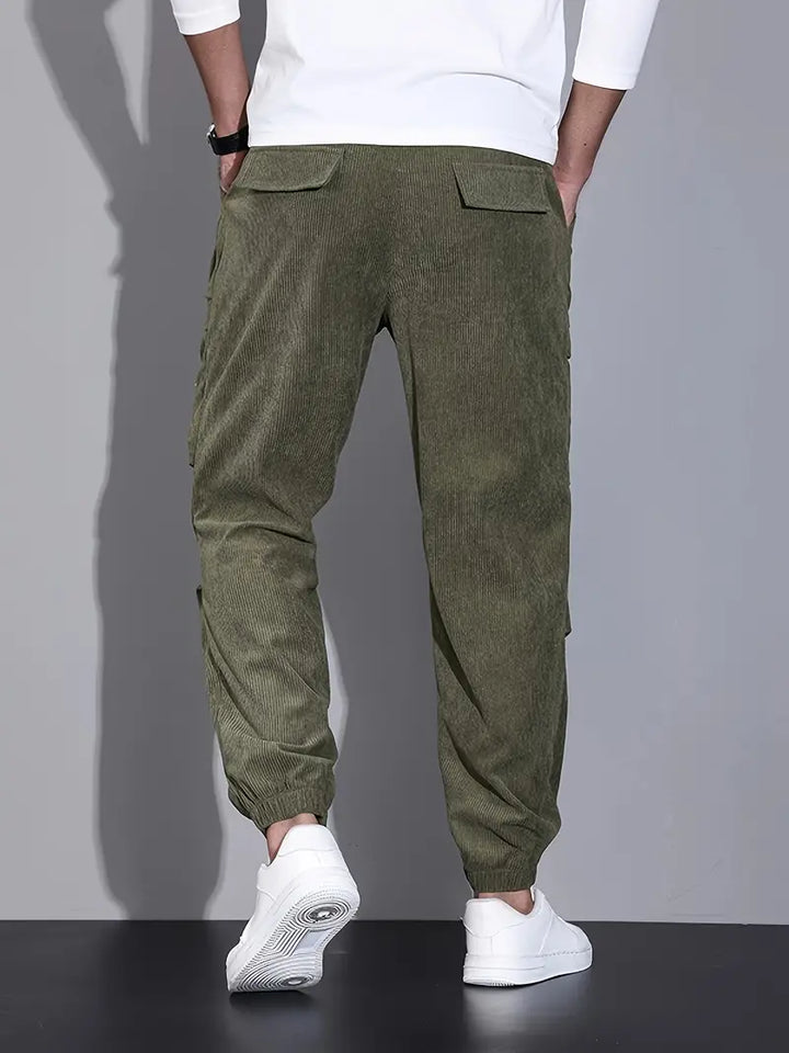 Gros plan sur un pantalon cargo homme noir, détails multipoches, tissu résistant pour toutes saisons.