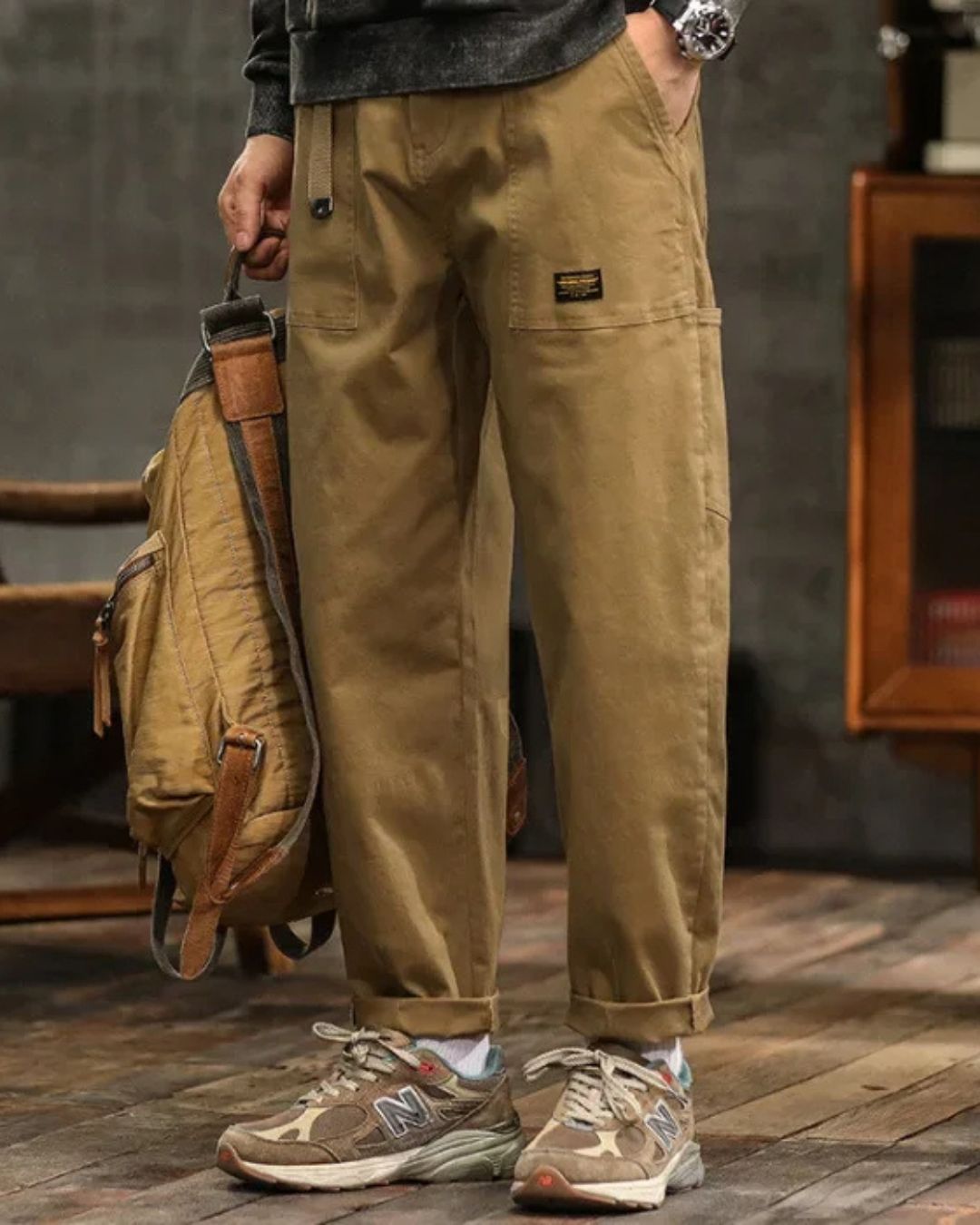 Homme portant un pantalon cargo vintage beige, coupe droite décontractée, avec ses poches fonctionnelles. Mode masculine.