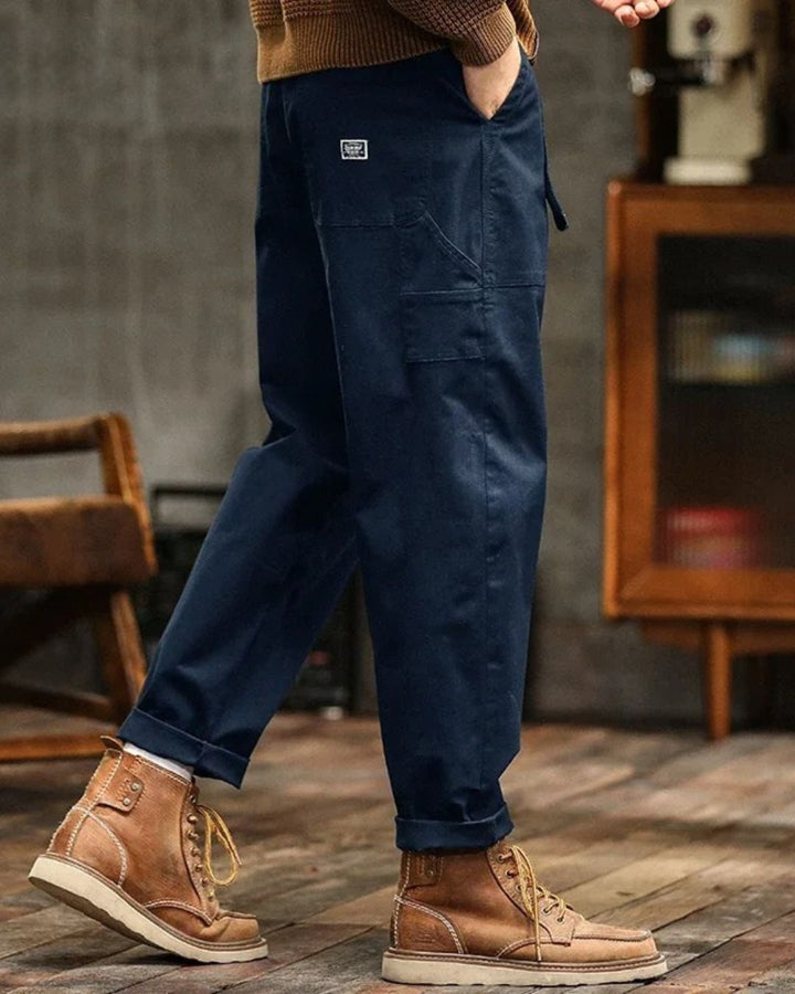 Gros plan sur les poches utilitaires du pantalon cargo homme style vintage, pratique pour l'extérieur et le quotidien urbain.