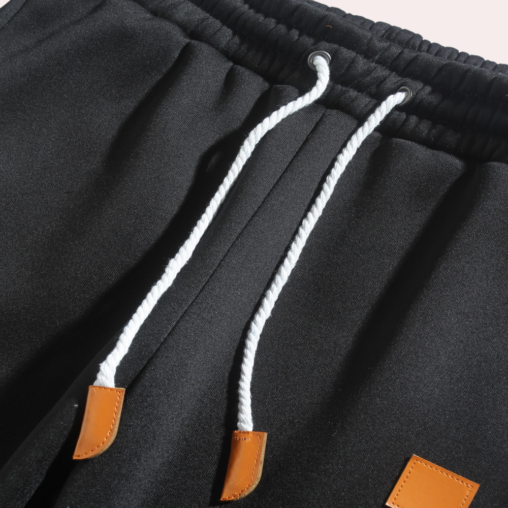 Pantalon de sport homme bleu marine, coupe ajustée, parfait pour un look athleisure élégant.