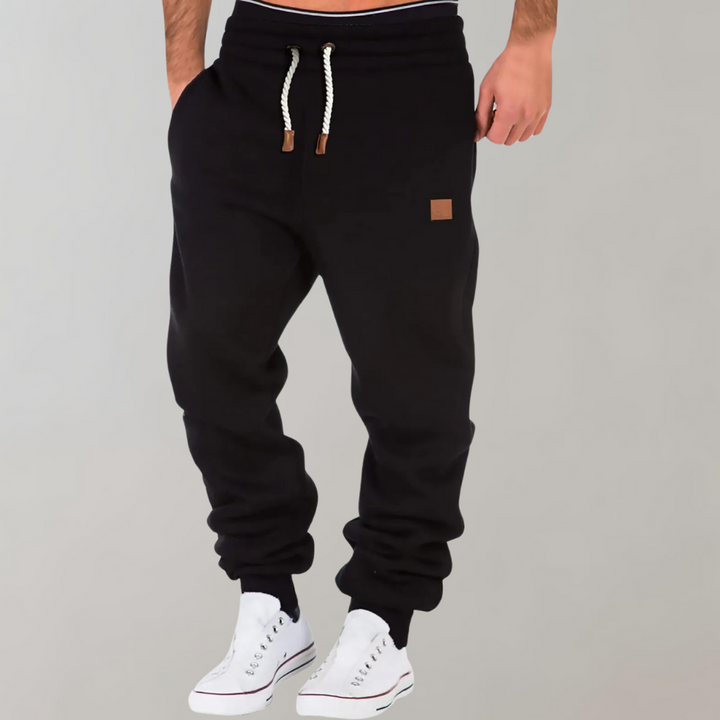 Homme actif portant un pantalon de sport jogging noir, parfait pour l'entraînement et le confort.
