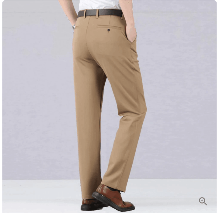 Homme portant un pantalon ajusté extensible noir, marchant avec aisance, look élégant et décontracté.