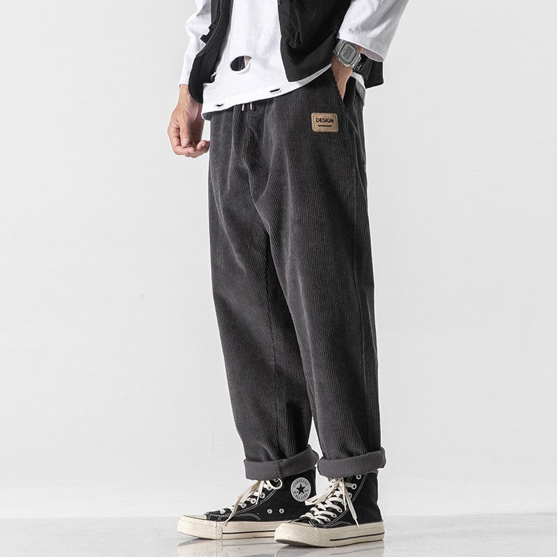Gros plan sur la texture du pantalon homme en velours côtelé noir. Tissu doux et confortable pour l'hiver décontracté.