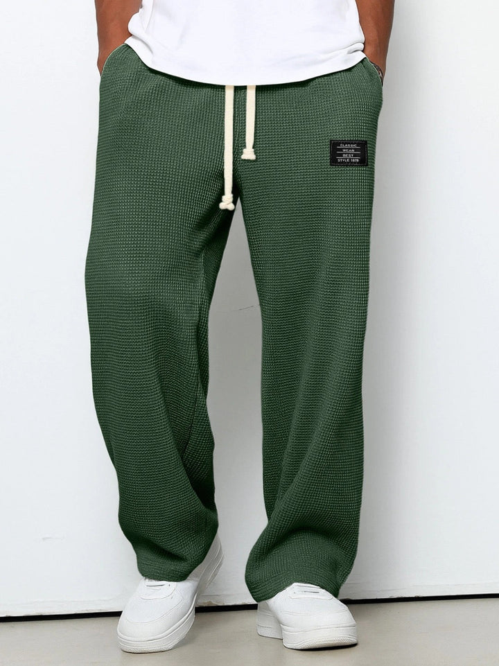 Gros plan de la taille élastique d'un pantalon jogger homme décontracté, texture gaufrée.