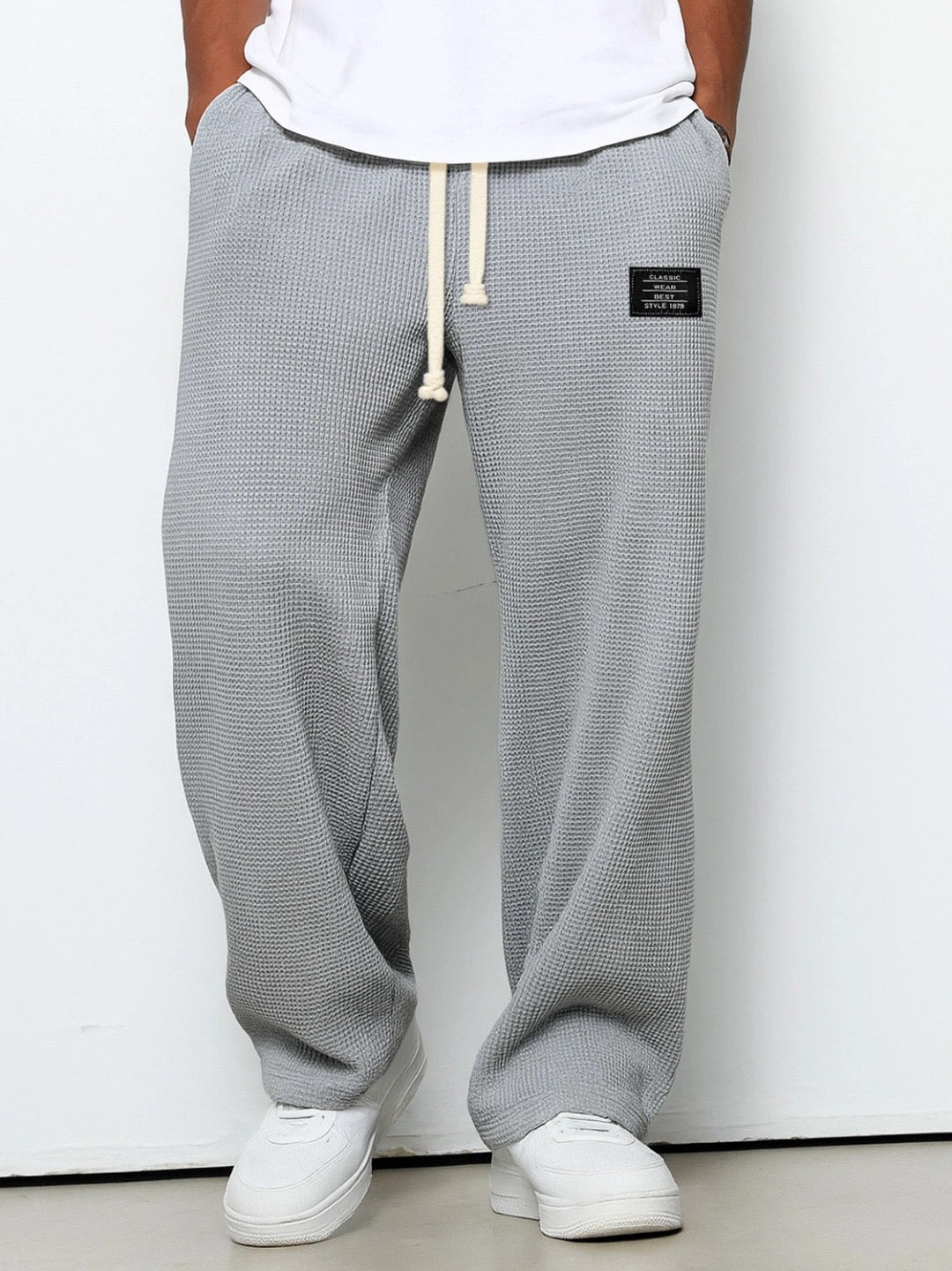 Pantalon homme couleur sable, coupe ample et décontractée, texture gaufrée, style jogger.