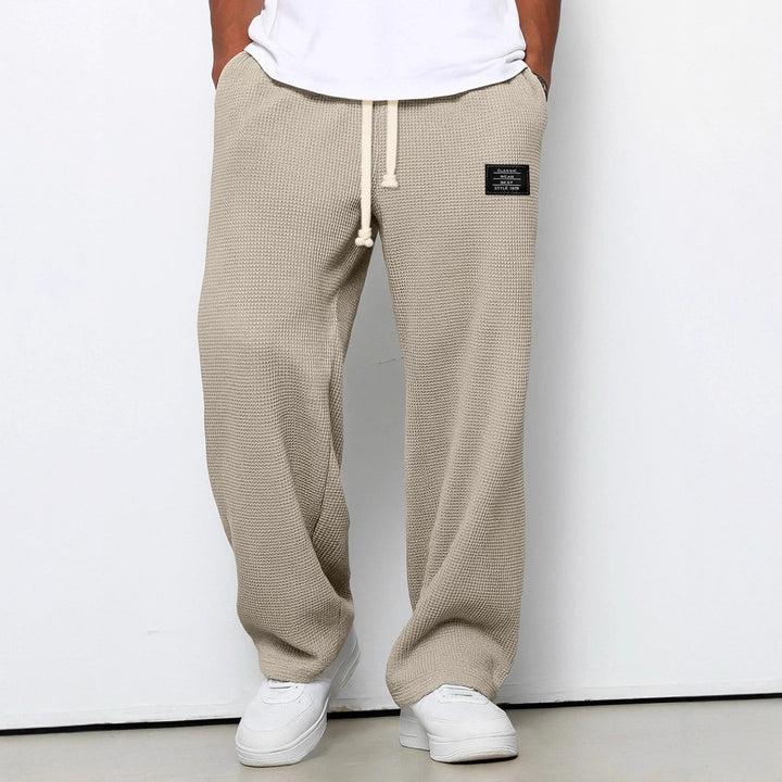 Détail du tissu gaufré respirant sur un pantalon jogger homme, confort et mode décontractée.