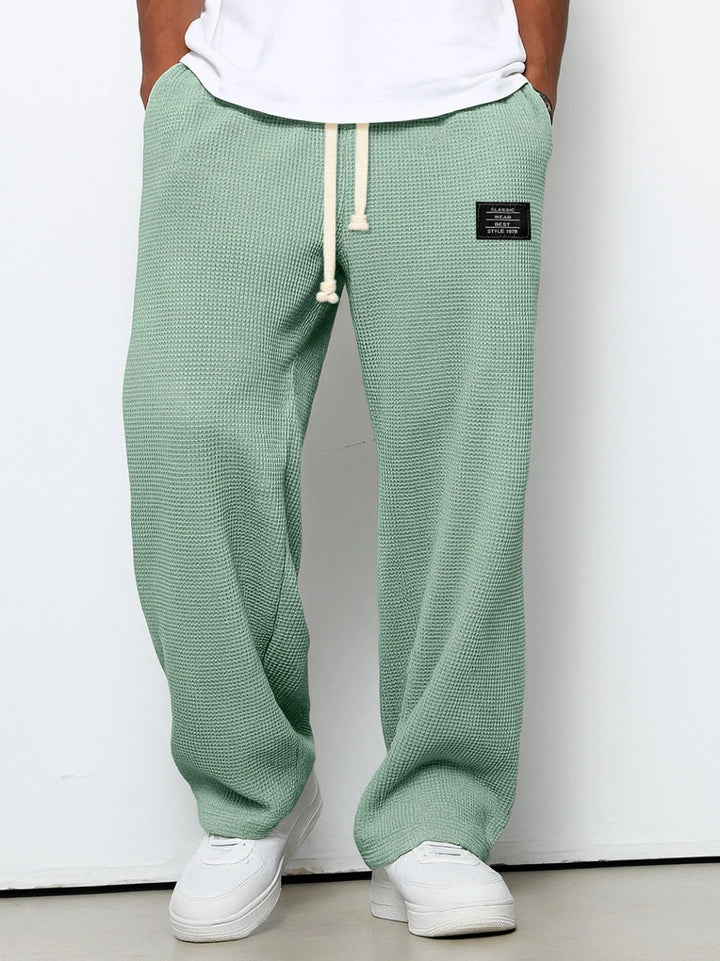 Pantalon décontracté homme beige à motif gaufré, idéal pour un look casual et confortable.