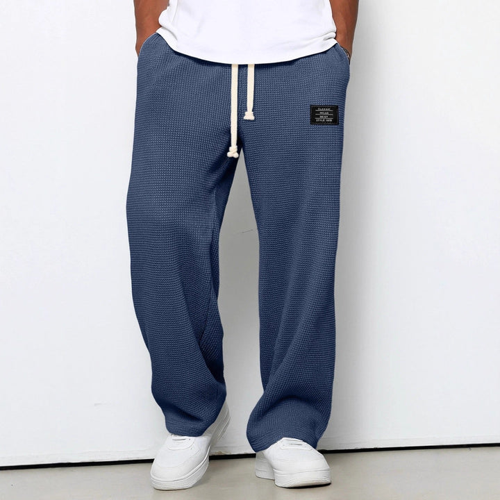 Style quotidien: Homme marchant avec un pantalon gaufré ample, confort premium.