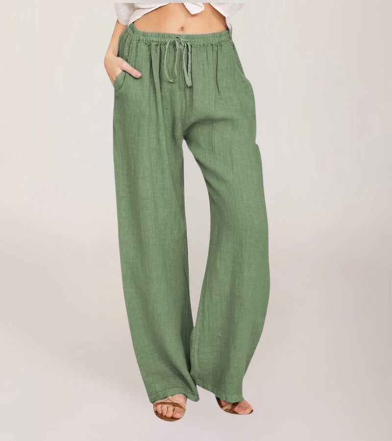 Femme portant un pantalon large en lin taille haute, look d'été décontracté et chic pour vacances.