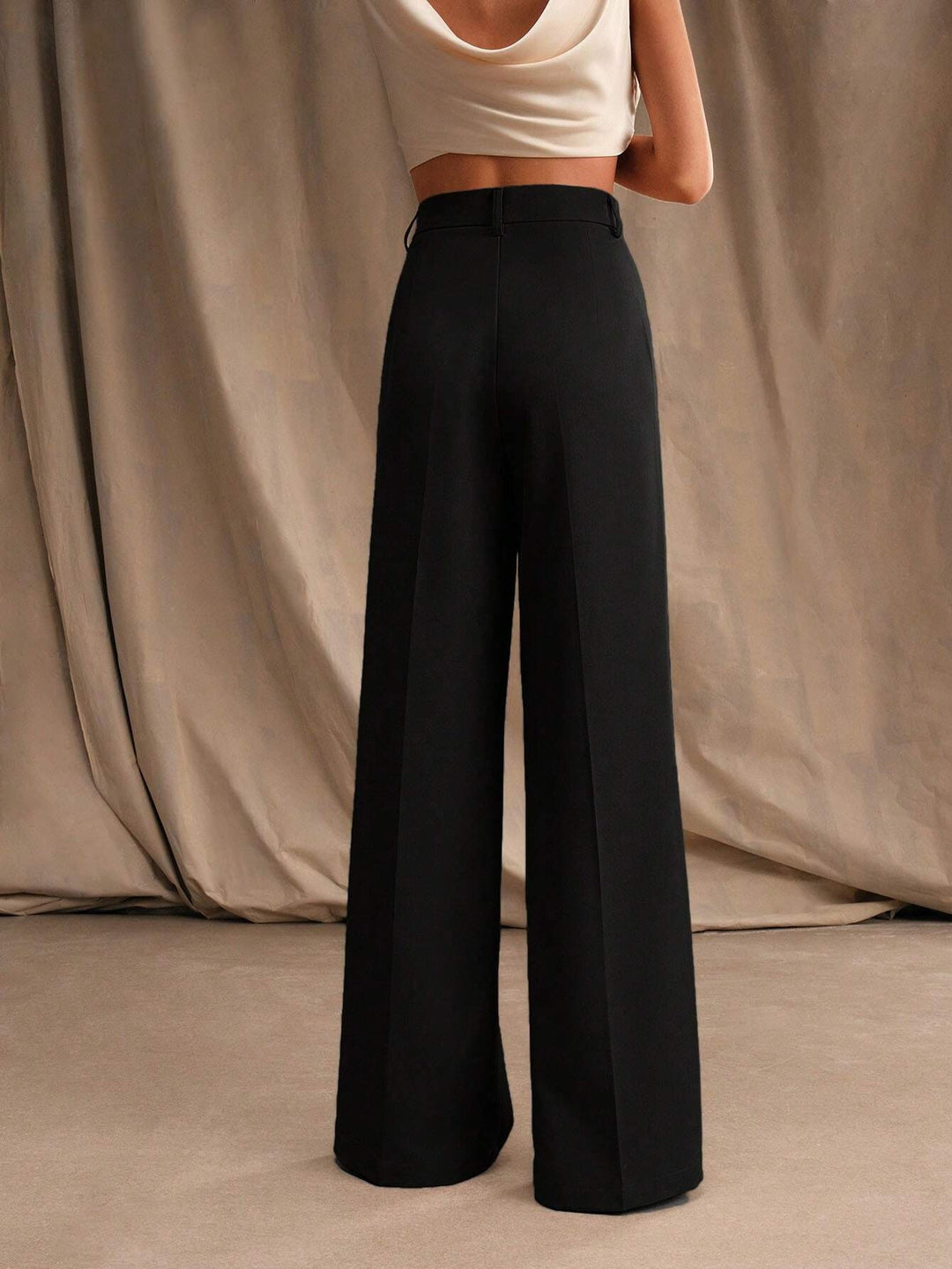 Détail des plis sur un pantalon large taille haute femme, style moderne et polyvalent.