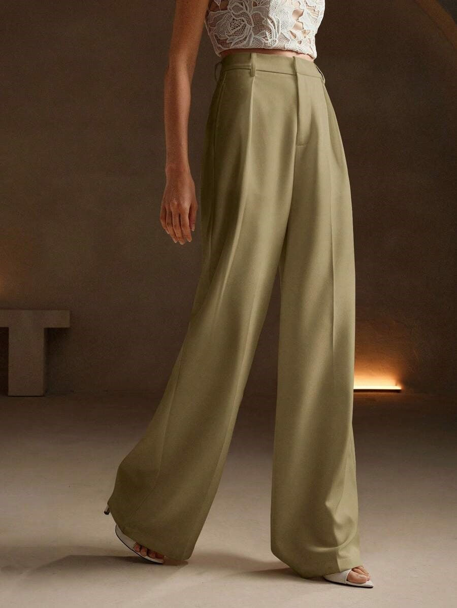 Pantalon large plissé taille haute en mouvement, illustrant sa fluidité et son confort.