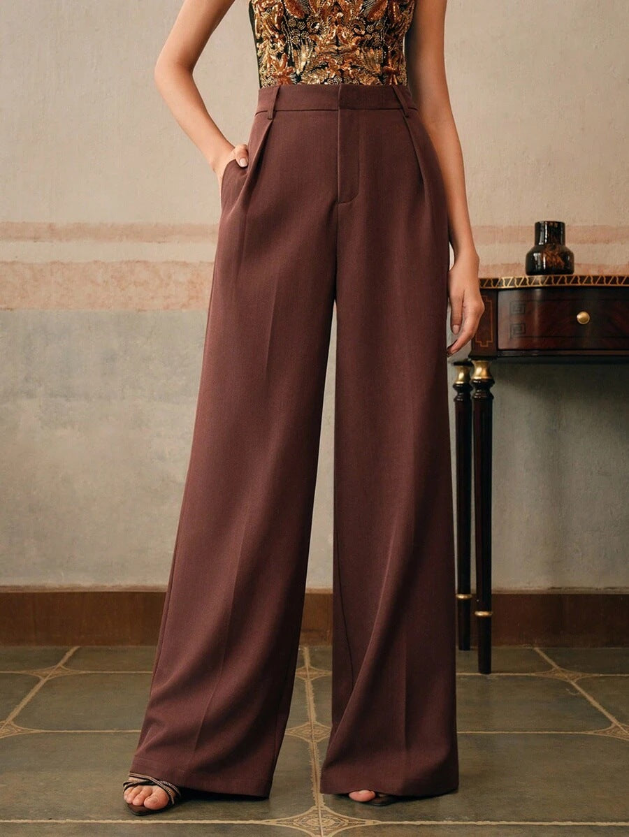 Gros plan sur le tissu plissé d'un pantalon large taille haute femme, qualité et douceur.