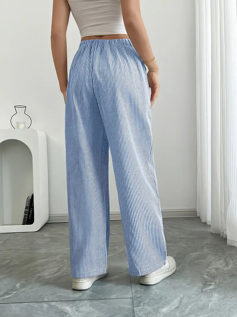 Mode été femme : pantalon large rayé, taille haute et chic.