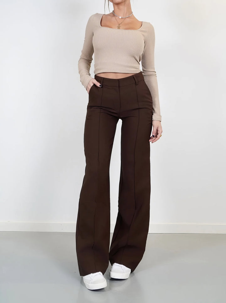 Pantalon chic pour femme, taille haute et coupe droite. Offre élégance et confort pour un look soigné.
