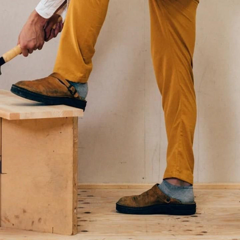 Pantoufles en cuir marron pour hommes, design ergonomique, semelle rembourrée, offrant un confort et un soutien optimal.