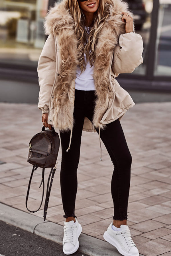 Femme souriante portant une parka courte hivernale chic, prête à affronter le froid avec élégance.