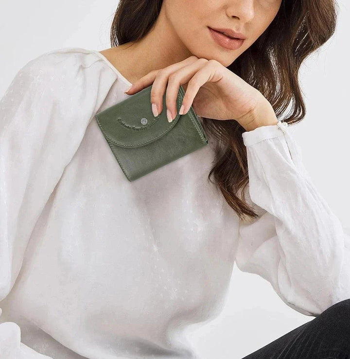 Porte-cartes compact en cuir véritable pour femme, dans une main, illustrant sa petite taille.