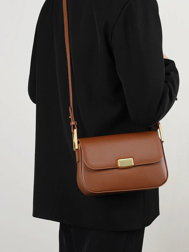 Détail du petit sac à main en cuir fendu : texture et qualité du matériau mises en valeur