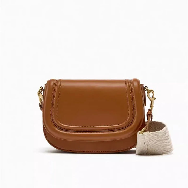 Petit sac bandoulière femme élégant, similicuir camel avec rabat et fermoir doré, porté épaule.
