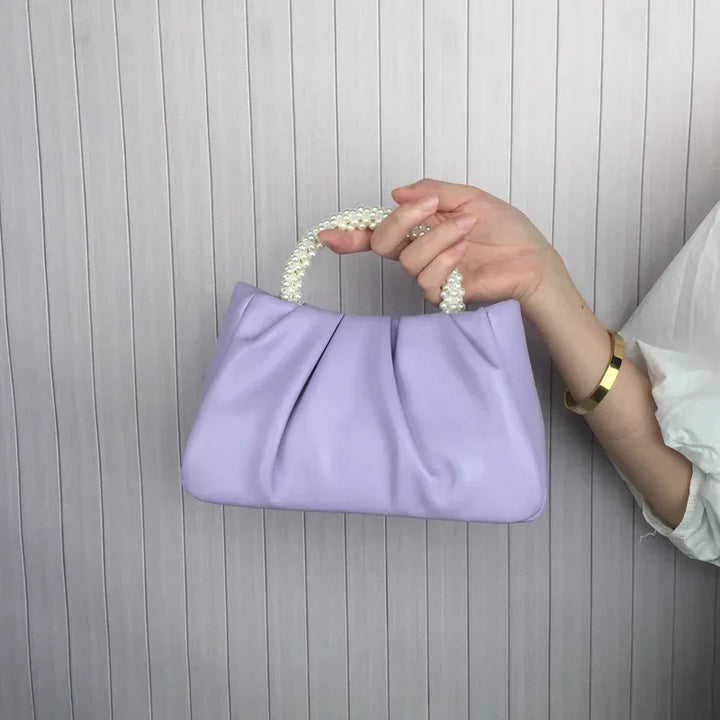 Sac de soirée blanc cassé, en satin avec une bordure perlée, idéal pour mariage ou cérémonie.