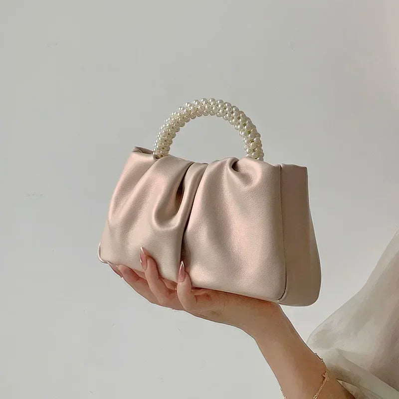 Sac à main femme en satin noir orné de perles, parfait pour une tenue de soirée chic.