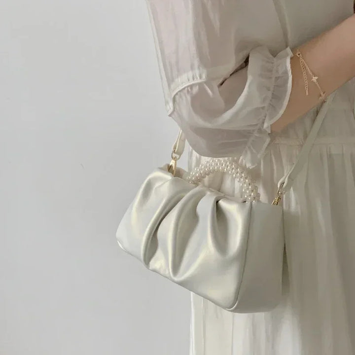 Sac de cérémonie blanc satiné avec perles brodées, accessoire mariage raffiné.