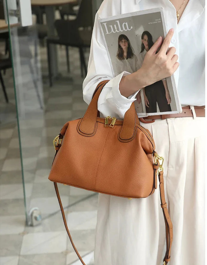Profil élégant d'un petit sac bandoulière femme en cuir fendu gris beige, compact et tendance.