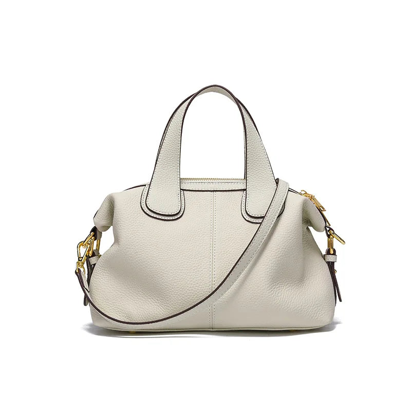 Détail de la fermeture d'un petit sac à main bandoulière femme en cuir fendu gris beige, sécurité chic.