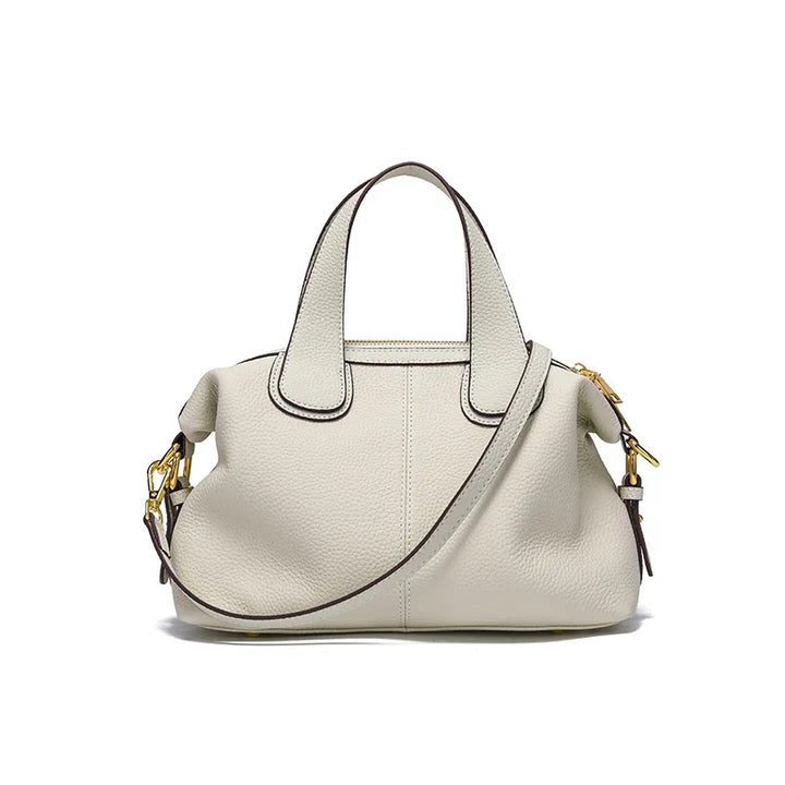 Détail de la fermeture d'un petit sac à main bandoulière femme en cuir fendu gris beige, sécurité chic.