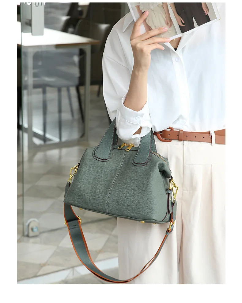 Femme élégante portant un petit sac à main bandoulière gris beige en cuir, accessoire mode.
