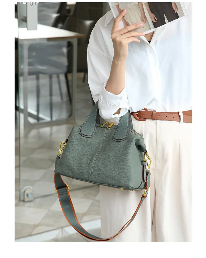 Femme élégante portant un petit sac à main bandoulière gris beige en cuir, accessoire mode.