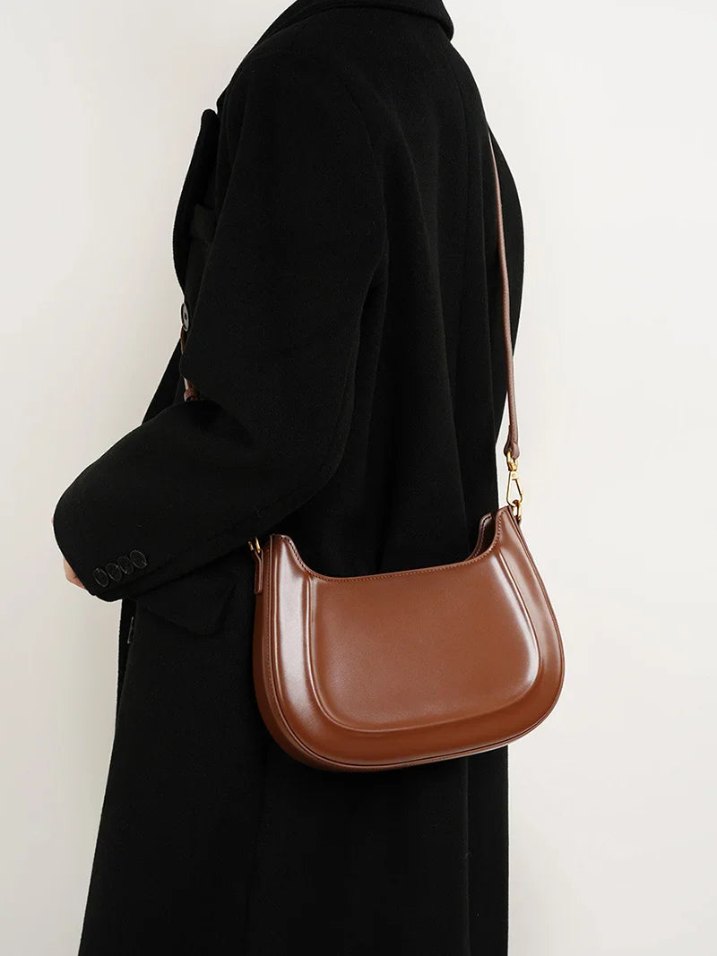Gros plan d'un sac à main en cuir grainé marron, texture visible, accessoire de qualité