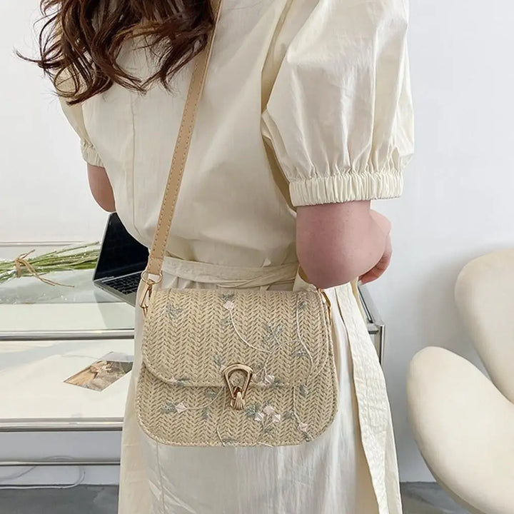 Sac bandoulière en paille naturelle pour femme, design floral délicat, parfait pour un look bohème élégant.