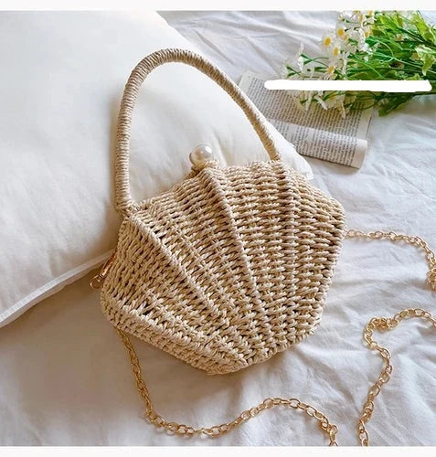 Sac bandoulière femme en paille naturelle tressée couleur crème. Forme coquillage unique, élégant et tendance pour l'été.
