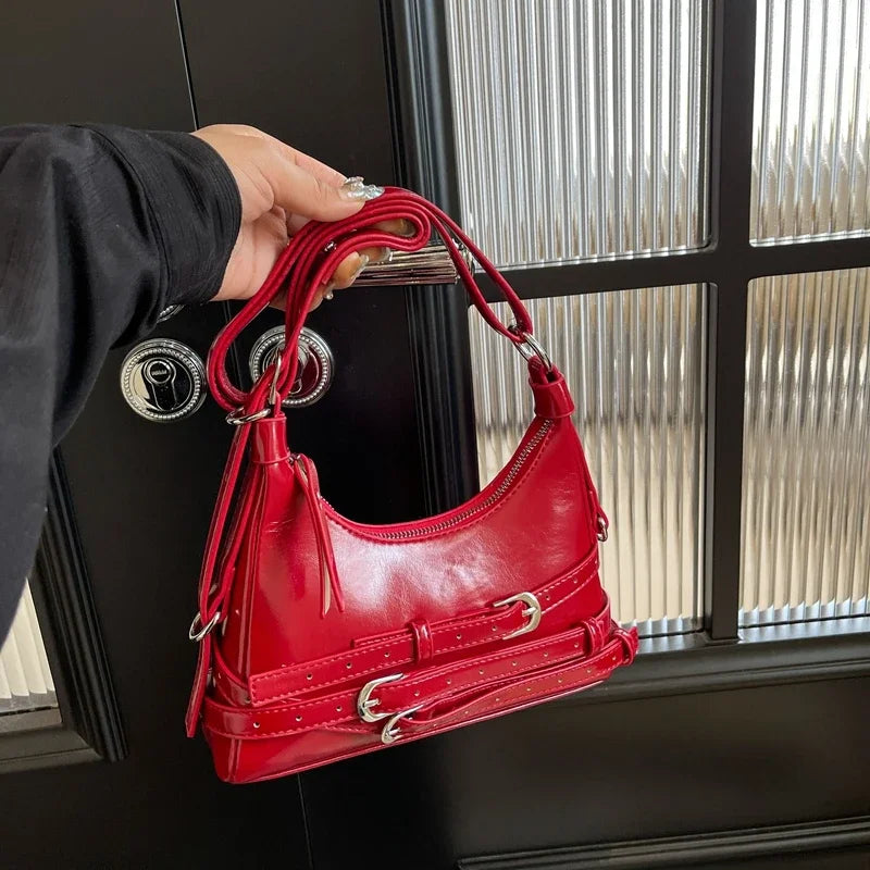 Sac bandoulière petit format pour femme en similicuir noir. Accessoire mode rock chic élégant.