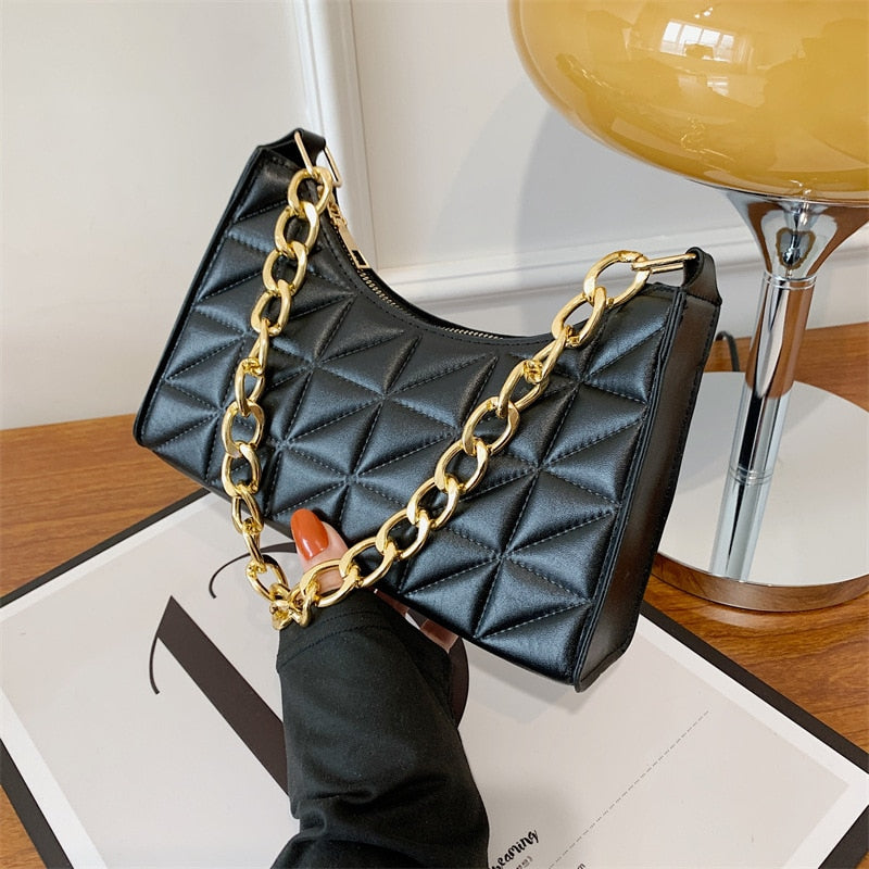 Sac à main femme noir en similicuir avec bandoulière chaîne dorée, idéal pour un look chic et sophistiqué.