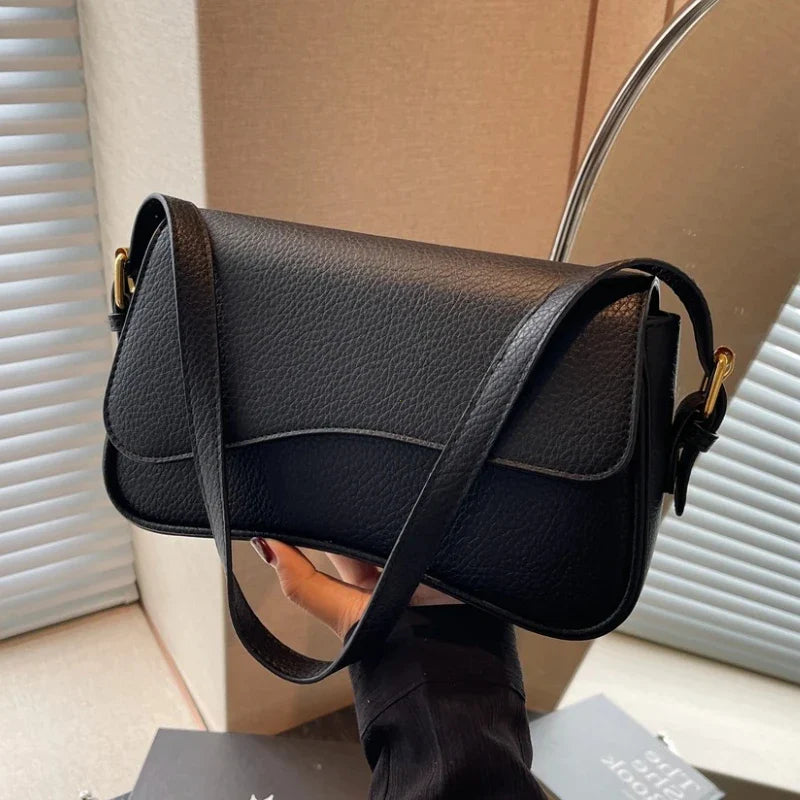 Petit sac à main noir élégant en cuir synthétique pour femme, idéal pour un look chic et tendance.