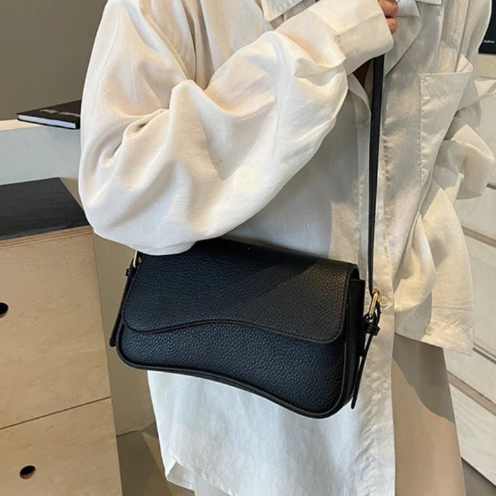 Sac bandoulière noir polyvalent en cuir synthétique pour femme, accessoire mode parfait pour l'épaule.